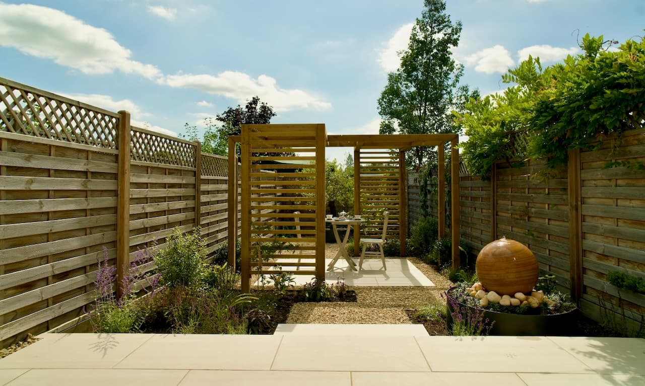 Sequence of timber pergolas leading to a stone sphere water feature