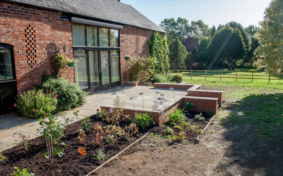 Large Cotswold country garden with sweeping natural-stone paving and layered planting beds