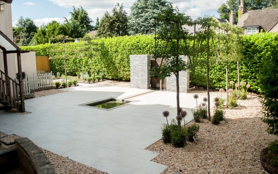 Landscaped grounds of a Cotswold grange hotel with formal terracing and stone walls